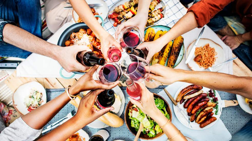 Hands toasting at dinner